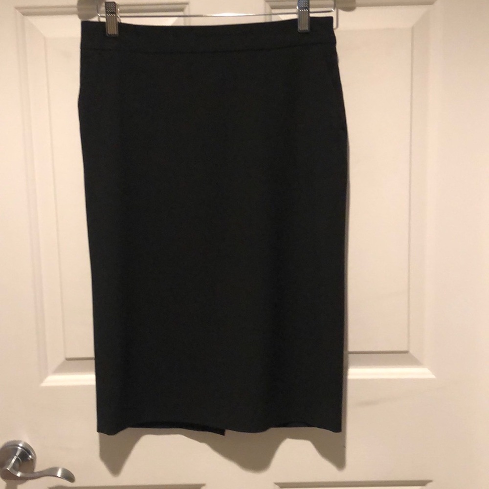 Stretch low waist pencil skirt with back slit. Zipper and pockets on the side.
